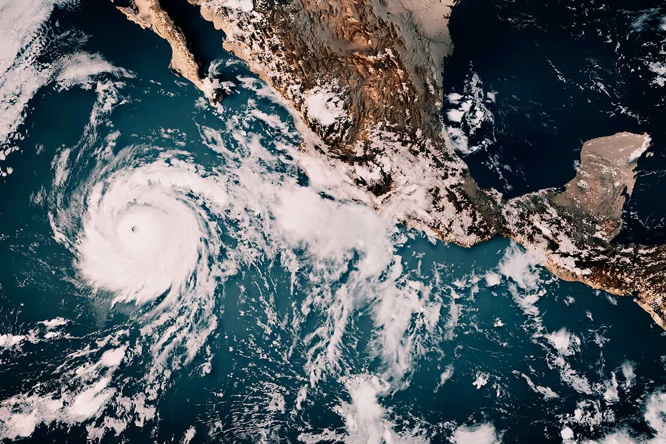 Satellite view of a hurricane approaching the coast of Mexico, showcasing swirling clouds and storm patterns.