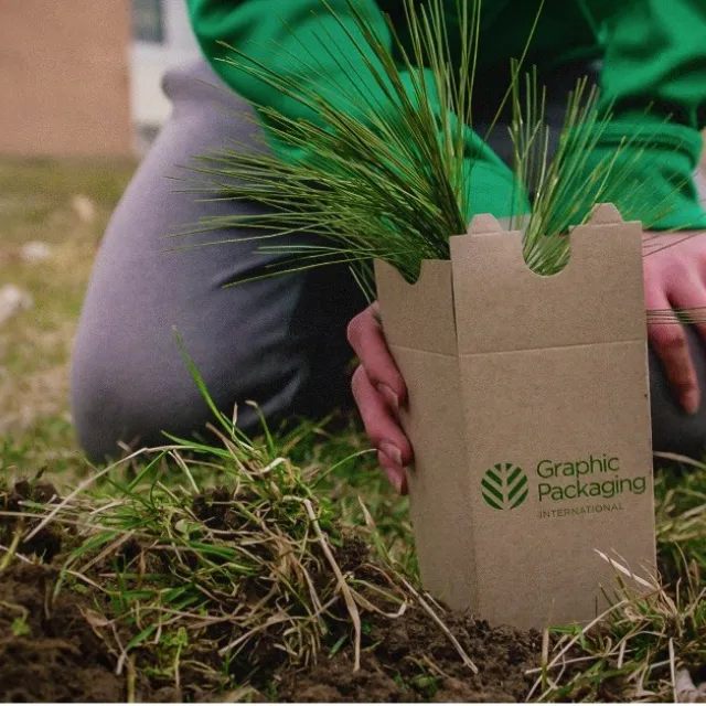 person kneeling with a seedling box
