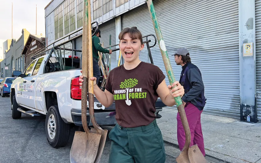 Girl holding shovels smiling