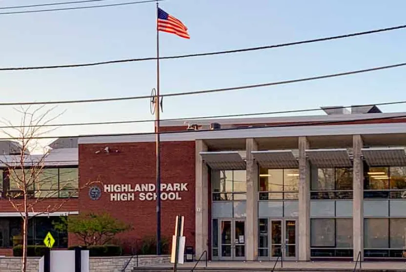 Highland Park High School building's front view with a flag waving.